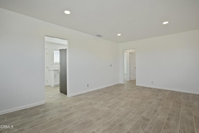 spare room with visible vents, recessed lighting, light wood-style flooring, and baseboards