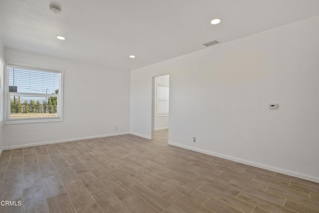 unfurnished room featuring recessed lighting, visible vents, baseboards, and wood finished floors
