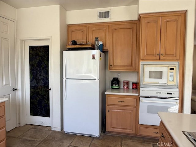 1050 Ginger Cir, Corona, CA 92879 - kitchen with light countertops, stone finish flooring, white appliances, and visible vents