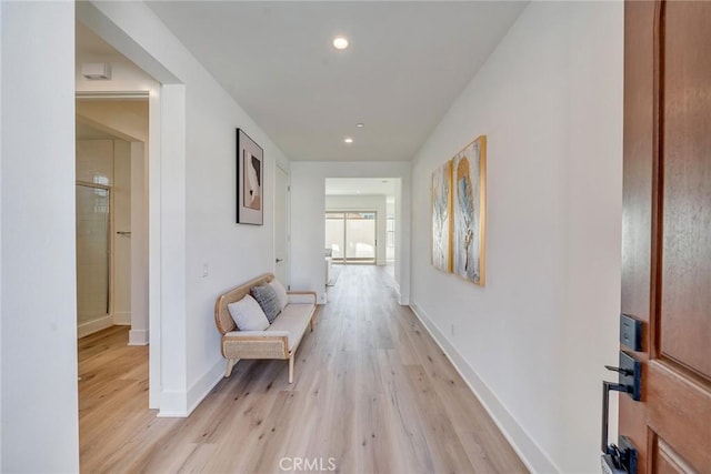 hallway with recessed lighting, light wood-style floors, and baseboards