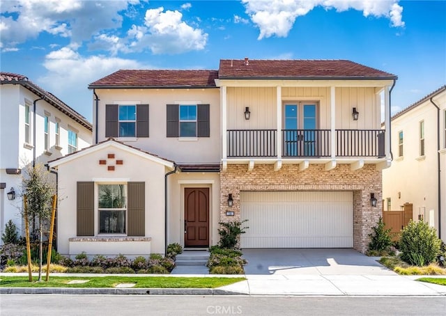 view of front facade with an attached garage, stucco siding, a balcony, and concrete driveway