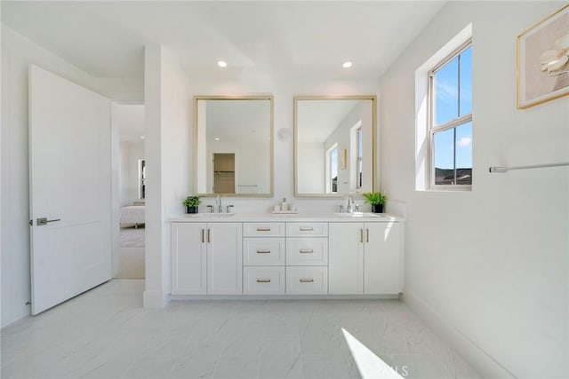 ensuite bathroom featuring ensuite bath, a sink, recessed lighting, and double vanity