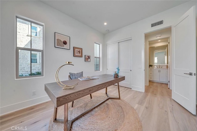 office space with recessed lighting, visible vents, light wood finished floors, and baseboards