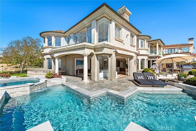 31821 Monarch Crst, Laguna Niguel, CA 92677 - back of house featuring a balcony, a patio area, a pool with connected hot tub, and a chimney