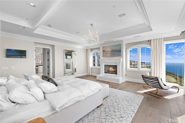 31821 Monarch Crst, Laguna Niguel, CA 92677 - bedroom featuring a glass covered fireplace, wood finished floors, a tray ceiling, a chandelier, and crown molding