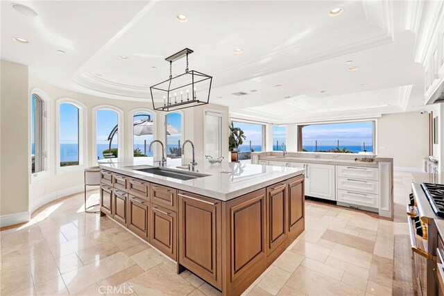 31821 Monarch Crst, Laguna Niguel, CA 92677 - kitchen with a raised ceiling, a large island with sink, brown cabinets, recessed lighting, and white cabinets
