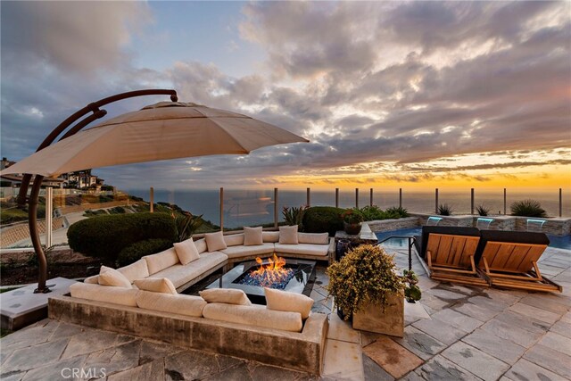 31821 Monarch Crst, Laguna Niguel, CA 92677 - patio terrace at dusk with a fire pit, a patio area, an outdoor pool, and a water view