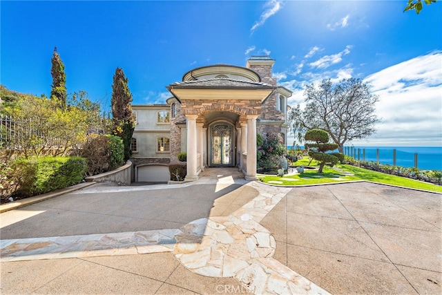 31821 Monarch Crst, Laguna Niguel, CA 92677 - entrance to property featuring stone siding, a water view, a chimney, and stucco siding