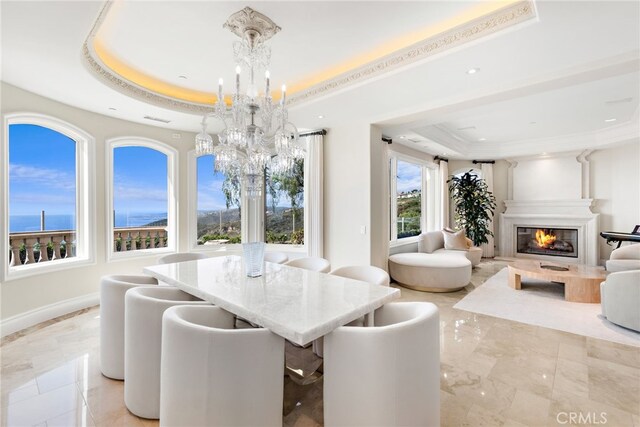 31821 Monarch Crst, Laguna Niguel, CA 92677 - dining area with a tray ceiling, a chandelier, light marble finish flooring, a glass covered fireplace, and recessed lighting