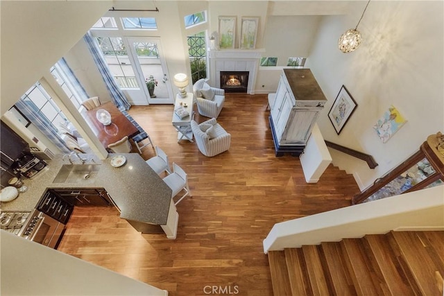 living area featuring stairs, wood finished floors, a fireplace, and baseboards