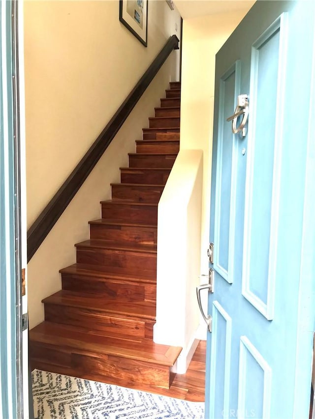 foyer featuring stairs and wood finished floors