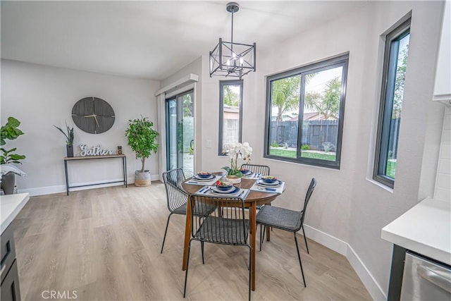 11845 Gladstone Ave, Sylmar, CA 91342 - dining space featuring light wood-style floors, a chandelier, and baseboards