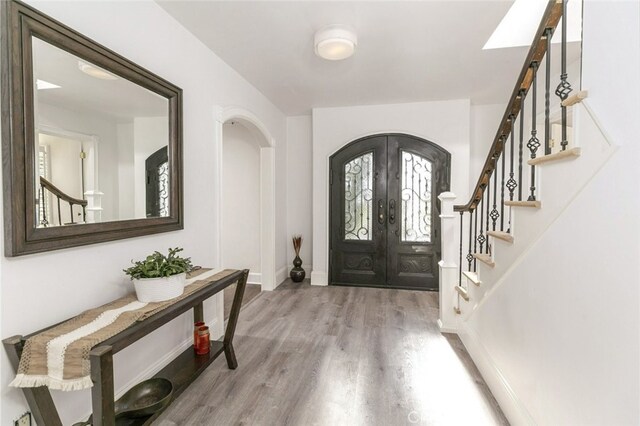449 Fern Dell Pl, Glendora, CA 91741 - foyer entrance with french doors, wood finished floors, stairs, baseboards, and arched walkways