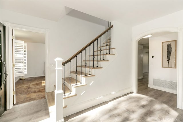 449 Fern Dell Pl, Glendora, CA 91741 - stairs featuring wood finished floors, arched walkways, and baseboards