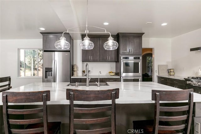 449 Fern Dell Pl, Glendora, CA 91741 - kitchen featuring appliances with stainless steel finishes, a sink, dark brown cabinets, an island with sink, and recessed lighting