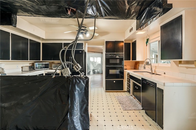 8017 Floral Ave, Los Angeles, CA 90046 - kitchen featuring dark cabinetry, light floors, visible vents, a sink, and black appliances