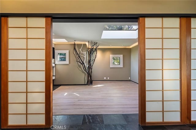 interior space featuring crown molding and a skylight