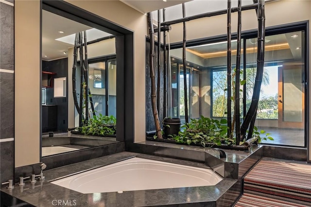 full bathroom with a garden tub and plenty of natural light