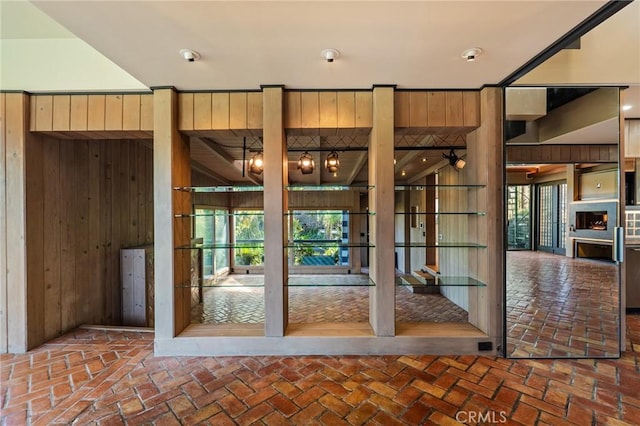 doorway to outside with brick floor and wood walls