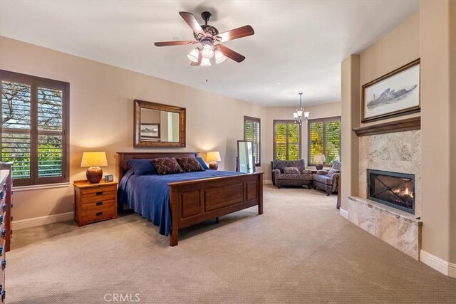 1065 Burnt Rock Way, Templeton, CA 93465 - bedroom with ceiling fan with notable chandelier, light carpet, a tiled fireplace, and baseboards