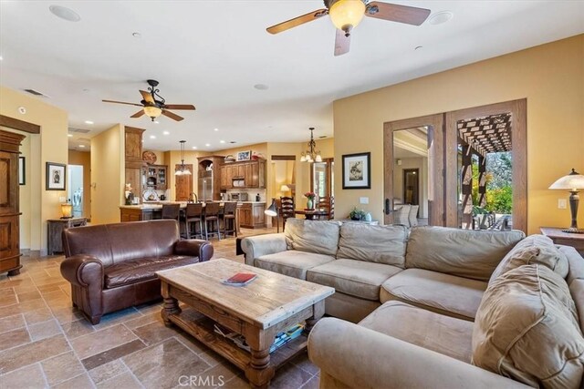 1065 Burnt Rock Way, Templeton, CA 93465 - living area featuring ceiling fan with notable chandelier and stone tile flooring