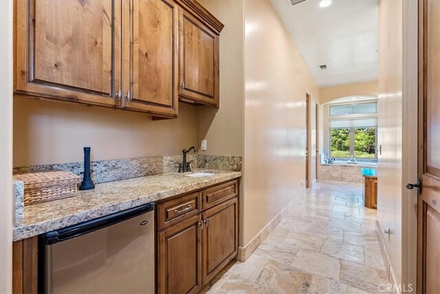 1065 Burnt Rock Way, Templeton, CA 93465 - interior space featuring refrigerator, a sink, stone tile floors, baseboards, and light stone countertops