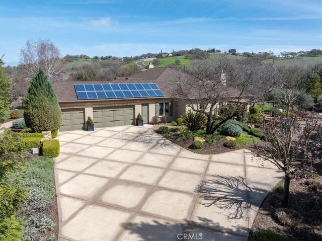 1065 Burnt Rock Way, Templeton, CA 93465 - view of front of home with concrete driveway, roof mounted solar panels, stucco siding, and a garage