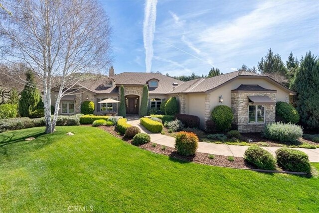 1065 Burnt Rock Way, Templeton, CA 93465 - view of front of property featuring stone siding, a chimney, a garage, a front yard, and stucco siding