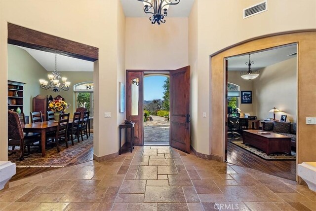 1065 Burnt Rock Way, Templeton, CA 93465 - entryway with stone tile floors, a towering ceiling, baseboards, a chandelier, and visible vents
