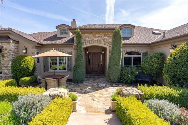 1065 Burnt Rock Way, Templeton, CA 93465 - view of front of house with a chimney, a patio area, and stone siding
