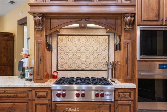 1065 Burnt Rock Way, Templeton, CA 93465 - kitchen with visible vents, backsplash, brown cabinets, light stone counters, and appliances with stainless steel finishes