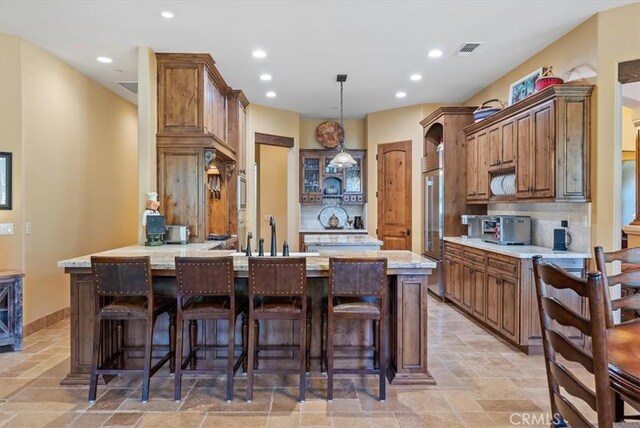 1065 Burnt Rock Way, Templeton, CA 93465 - kitchen with recessed lighting, visible vents, stone tile flooring, a peninsula, and a kitchen bar