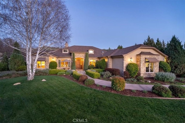 1065 Burnt Rock Way, Templeton, CA 93465 - view of front facade with stucco siding, a front lawn, stone siding, and a garage