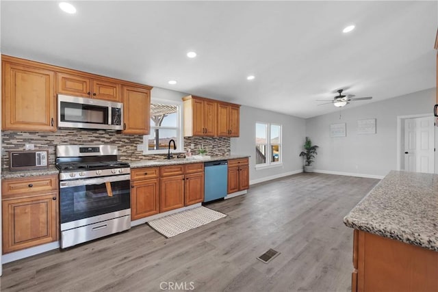 36090 Old Woman Springs Rd, Lucerne Valley, CA 92356 - kitchen featuring light wood-style flooring, a sink, tasteful backsplash, appliances with stainless steel finishes, and ceiling fan