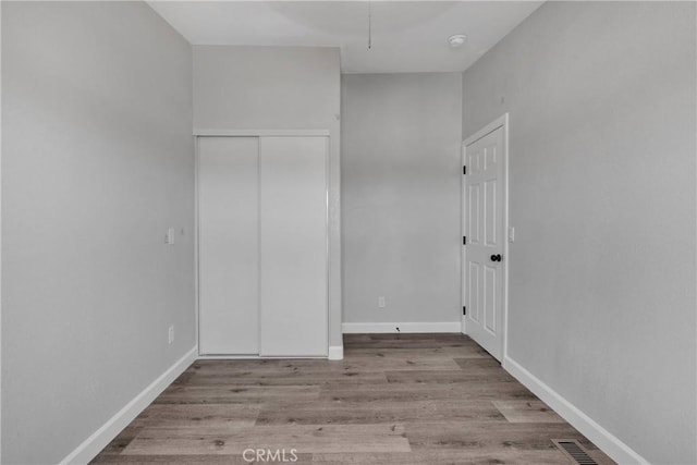 36090 Old Woman Springs Rd, Lucerne Valley, CA 92356 - unfurnished bedroom with a closet, baseboards, and wood finished floors