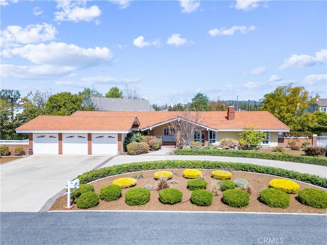 view of front of home with driveway, a garage, and a tiled roof