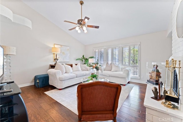 living area with ceiling fan, dark wood-style flooring, high vaulted ceiling, and baseboards