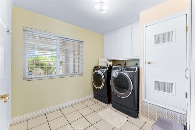 laundry room featuring cabinet space, independent washer and dryer, baseboards, and light tile patterned floors