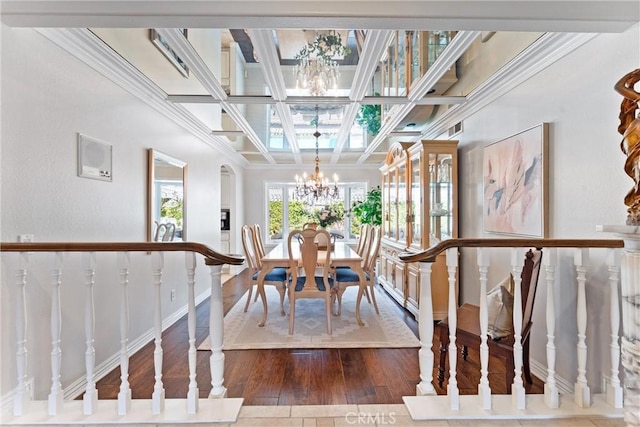 dining area featuring a chandelier, ornamental molding, hardwood / wood-style floors, coffered ceiling, and baseboards