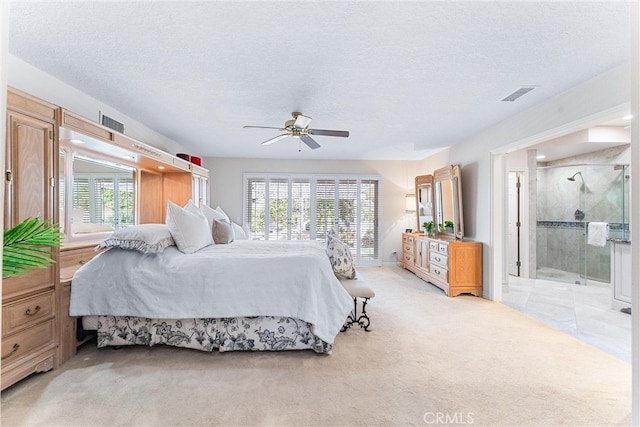 bedroom with multiple windows, light carpet, a textured ceiling, ensuite bathroom, and ceiling fan