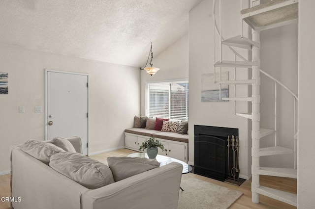 5125 W Wooley Rd Unit 5, Oxnard, CA 93035 - living area with light wood-style flooring, vaulted ceiling, a textured ceiling, and a fireplace with flush hearth