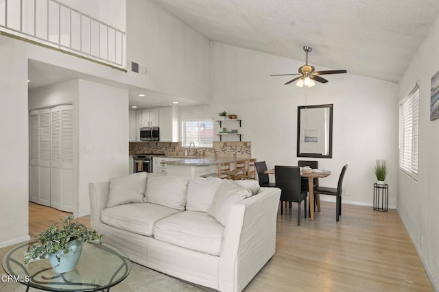 5125 W Wooley Rd Unit 5, Oxnard, CA 93035 - living room featuring lofted ceiling, ceiling fan, and light wood-style flooring