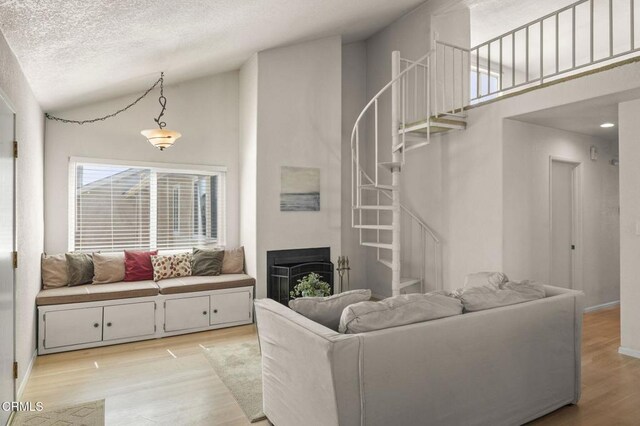 5125 W Wooley Rd Unit 5, Oxnard, CA 93035 - living room featuring stairway, light wood-style flooring, high vaulted ceiling, a fireplace, and a textured ceiling
