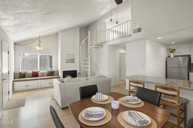 5125 W Wooley Rd Unit 5, Oxnard, CA 93035 - dining space featuring stairs, a textured ceiling, high vaulted ceiling, and light wood-type flooring