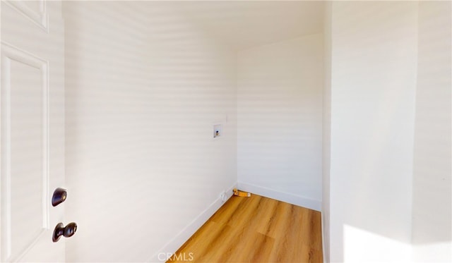spare room with baseboards and light wood-type flooring