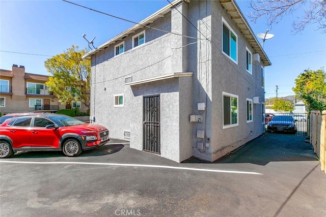 exterior space featuring stucco siding and fence