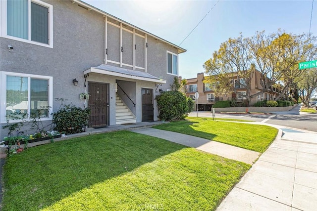 multi unit property featuring stucco siding and a front yard