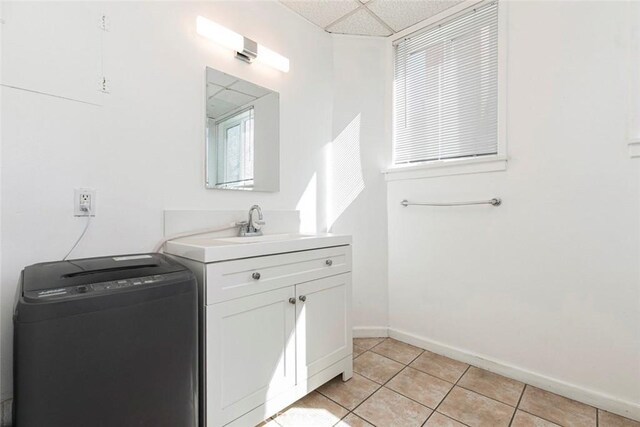bathroom featuring tile patterned flooring, a drop ceiling, vanity, and baseboards