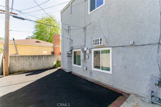 exterior space with a patio area, stucco siding, and fence