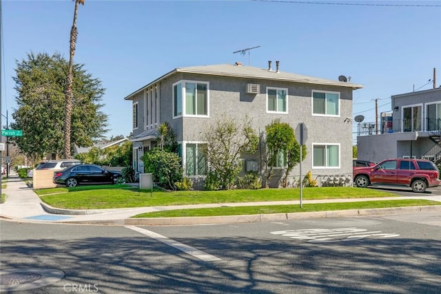 view of front facade with stucco siding and a front lawn